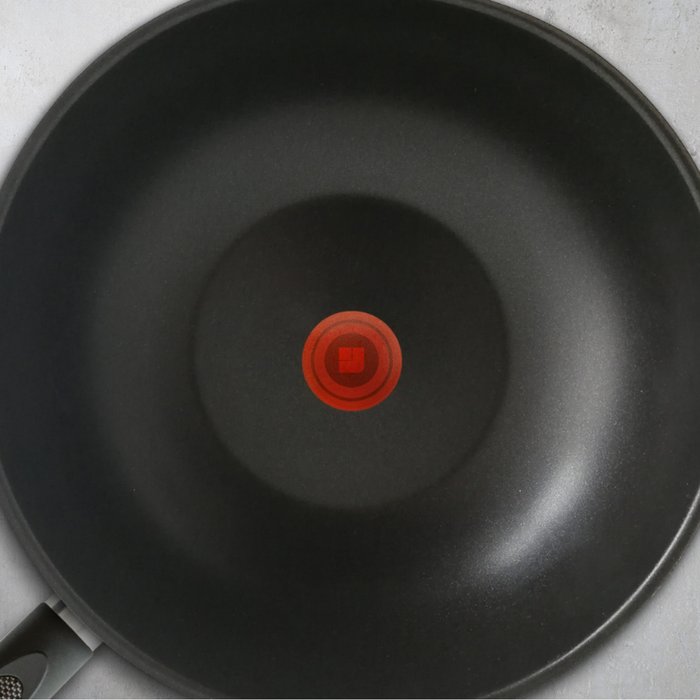 Schwarz beschichtete Innenseite einer Bratpfanne mit einem roten Temperaturpunkt in der Mitte
