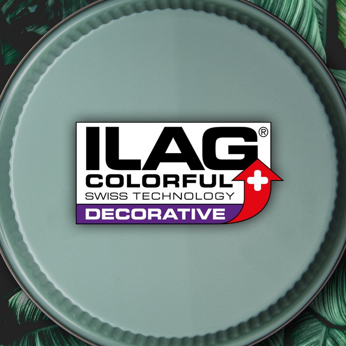 Resedagrüne Aussenseite eines runden Backblechs mit Wellenrand - mittig das ILAG Logo mit violett unterlegtem Decorative Schriftzug