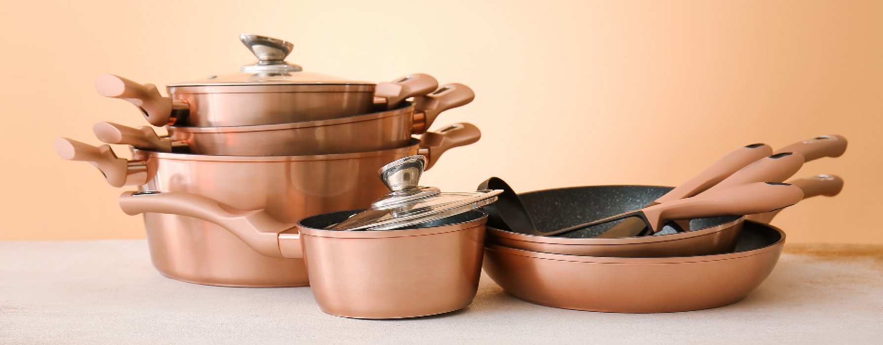 Stacked pan assortment. Pan outside is copper-colored and on the inside there is a black marbled coating.
