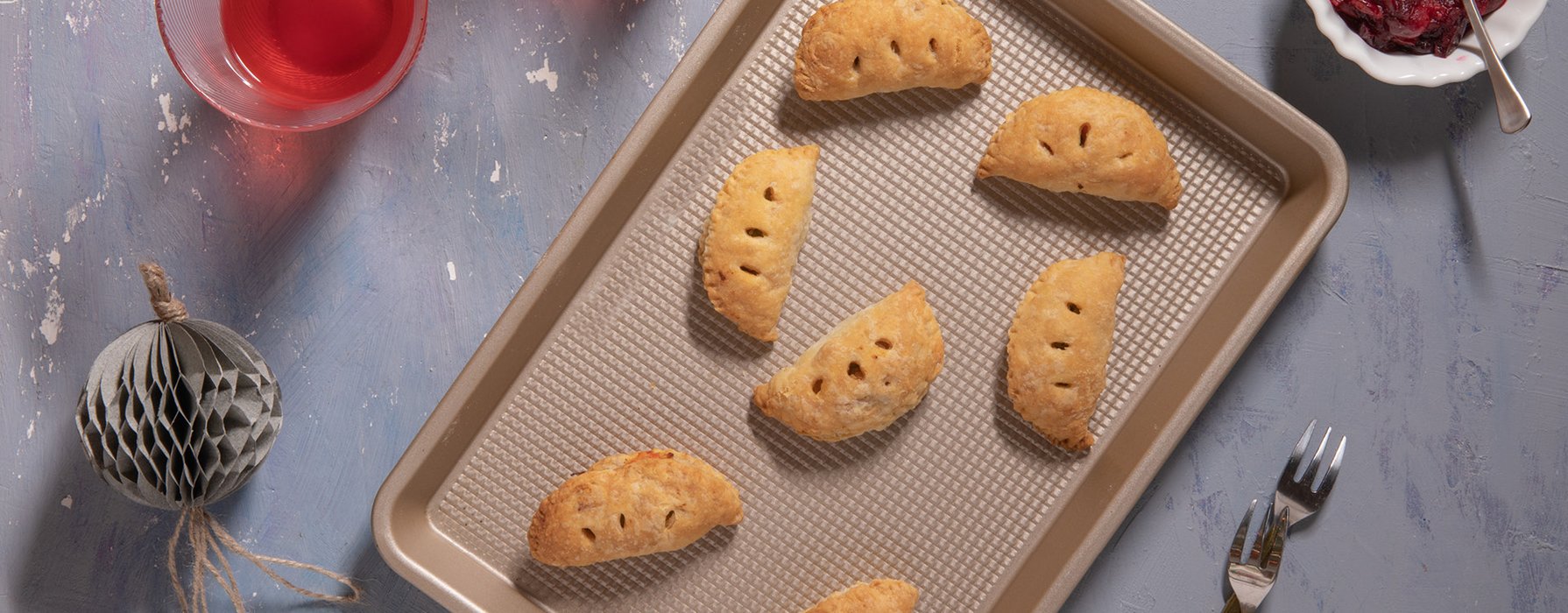 Baked pastries on a gold colored square metal sheet with corrugated base