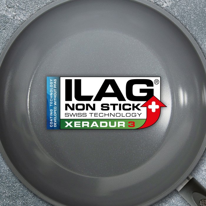 Grau glänzende Innenseite einer Bratpfanne - mittig das ILAG Logo mit dunkelgrün unterlegtem Xeradur 3 Schriftzug und links zusätzlicher Beschriftung "PFAS-FREE" in blau