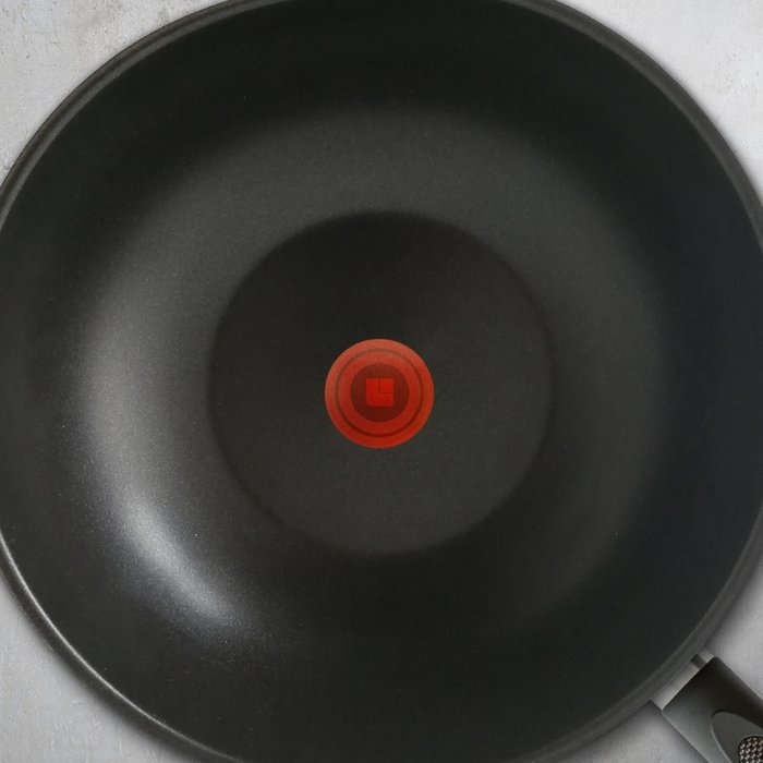 Schwarz beschichtete Innenseite einer Bratpfanne mit einem roten Temperaturpunkt in der Mitte